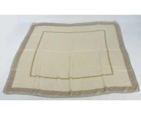 CHANEL; a silk scarf decorated with Celtic braided border on a cream logo textured ground, 85 x 85cm.