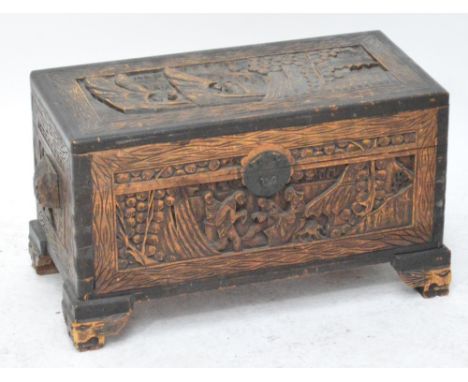 A small carved camphor wood blanket box, the hinged lid carved with figures in a landscape with carving to all sides, raised 