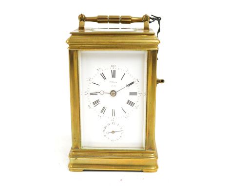 A late 19th century French brass cased carriage clock with swing loop handle above rectangular white enamel dial set with Rom