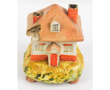 A mid 19th century Dudson trinket box and cover modelled as a cottage on naturalistic shaped base with four bun feet, hand in