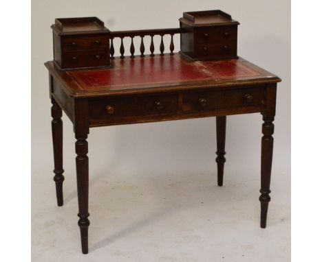 A Victorian mahogany writing desk, with a rounded rectangular top with two raised banks of two short drawers, leather inset w