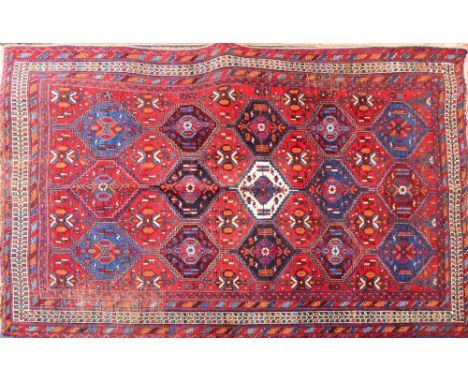 A vintage Persian Afshar rug decorated with hexagonal panels on a red ground within geometric decorated border, 192 x 142cm.
