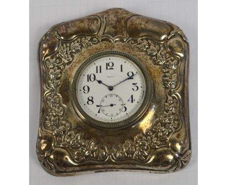 An Edward VII hallmarked silver framed travelling eight day timepiece of square form with domed top, embossed with floral and