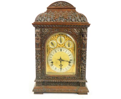 A large impressive Victorian carved oak bracket clock, the arched leaf and mask moulded pediment above arched dial set with s