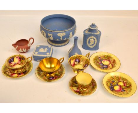 Four Wedgwood blue jasperware pieces, comprising a footed bowl, a bottle vase, trinket box and a tea canister, also a pink ja
