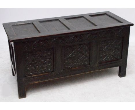 An 18th century oak coffer, the panelled top above a carved front raised on stile supports, width 132cm. CONDITION REPORT: Ca