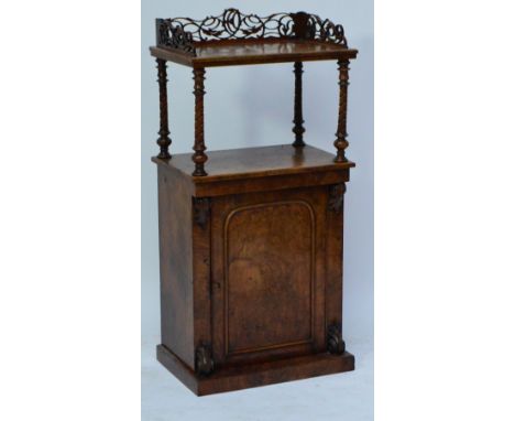 A Victorian walnut side cabinet, the upper shelf with three quarter pierced gallery above an arched cupboard door set with a 