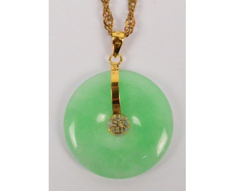 A Chinese jade bi-disc circular pendant suspended on a 9ct gold fine link chain, chain approx 3.4g, diameter of bi-disc 2.5cm