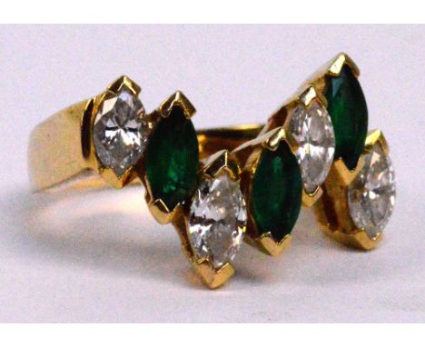 An 18ct yellow gold and emerald ring, set with four marquise cut diamonds and three emeralds in high chevron settings, size N