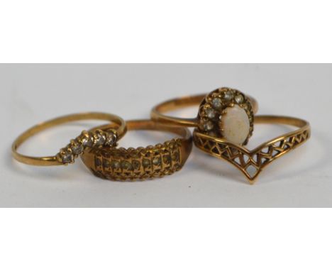 A group of four 9ct yellow gold costume rings including a pierced wishbone example and a cluster ring set with opal, combined