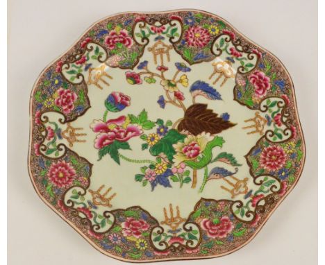 An 18th century Chinese porcelain plate of shaped circular form painted in enamels with floral and foliate sprays within simi