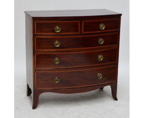 An early 19th century inlaid mahogany bowfronted chest of drawers of two short drawers and three long drawers with lion head 