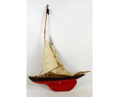 A vintage red and black pond yacht, "Britannia", with ticking sails, length 54cm. CONDITION REPORT: There is no second mast 