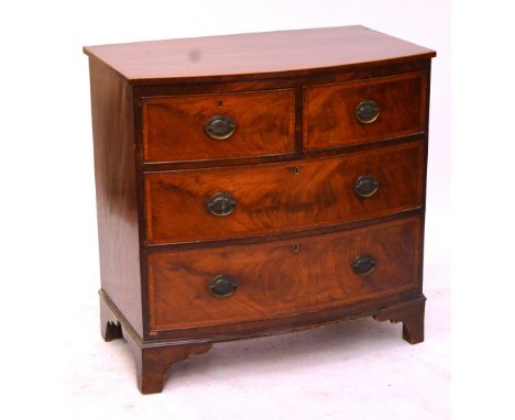 A small early 19th century mahogany and boxwood strung bowfronted chest of two short and two long drawers raised on bracket f