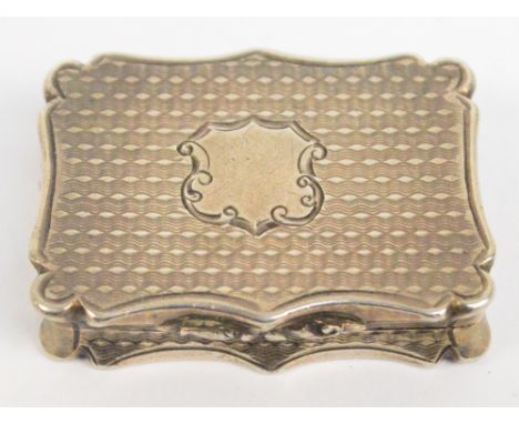 A Victorian hallmarked silver vinaigrette of shaped rectangular form with overall engine turned decoration, the hinged lid ce