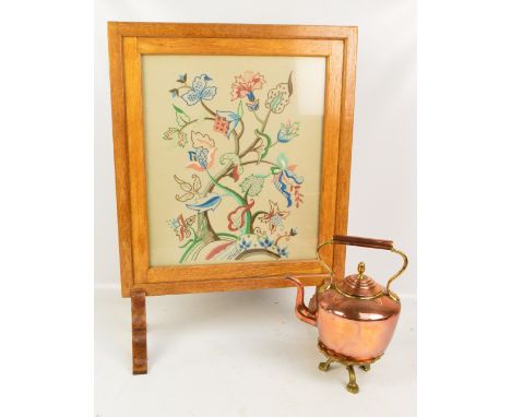 A mid 20th century blond oak framed fire screen set with an embroidered panel, height 80cm and a copper and brass kettle with