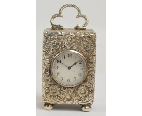 A late Victorian hallmarked silver miniature travelling carriage timepiece with swing loop handle, allover foliate scroll dec