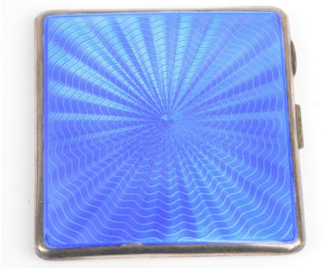 An Edward VIII hallmarked silver square section cigar case with blue guilloche enamel decorated hinged lid, with gilt wash in