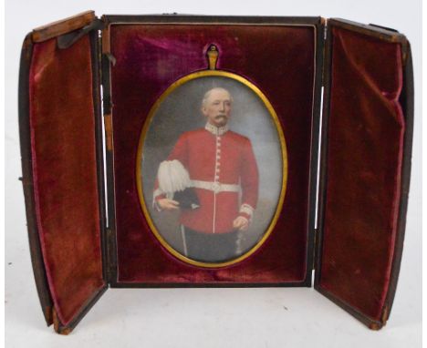 A large oval portrait miniature in folding leather case, depicting a man wearing red tunic holding a hat, the frame inscribed