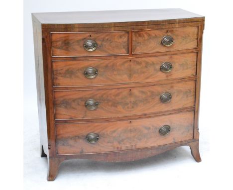 An early 19th century mahogany crossbanded bowfronted chest of two short and three long graduate drawers raised on splayed br