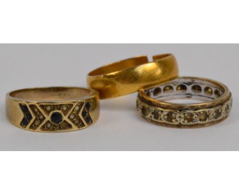 A 22ct yellow gold wedding band, size M (af), a further 9ct gold sapphire and clear stone set example and another unmarked et