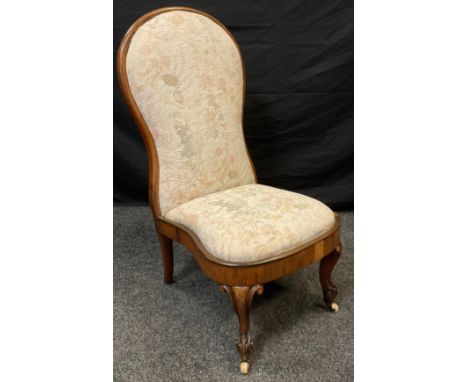A Victorian rosewood nursing chair, carved cabriole legs, ceramic casters, 95cm high, c.1870. 