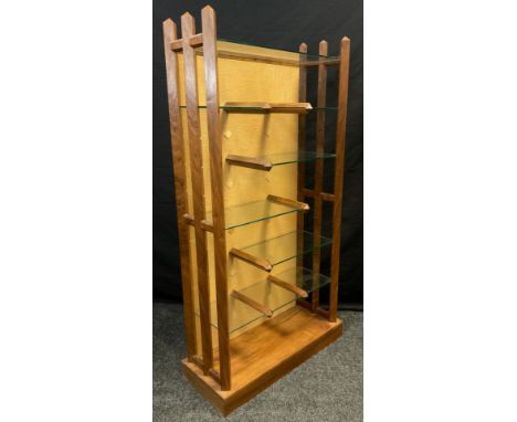 A modern walnut and glass adjustable shelving unit, 141cm high x 74cm wide x 31cm deep;  a 1950’s modern design teak and bras