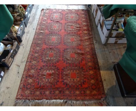 A Middle-Eastern carpet, having ten central lozenges of typical design within a repeating geometric shaped border (200cm x 10