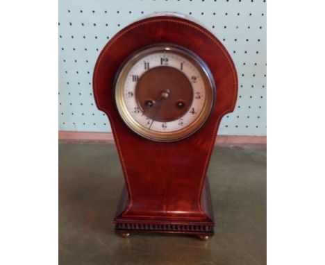 An Edwardian mahogany and inlaid mantle clock, having domed top over tapering body, the eight day striking movement behind a 