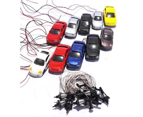 An unboxed group of HO scale plastic wired cars and lights, cars are wired for lights. suitable for a model railway display. 