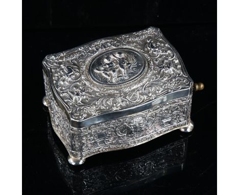 A 20th century German silver singing bird automaton music box, serpentine form with relief embossed putti and foliate decorat