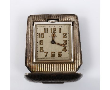 An Art Deco Continental sterling silver snakeskin travelling clock, by E Gubelin of Lucerne, silvered dial with Arabic numera