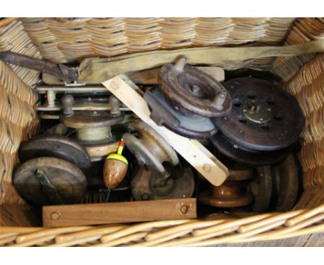 A fishing basket containing vintage fishing reels