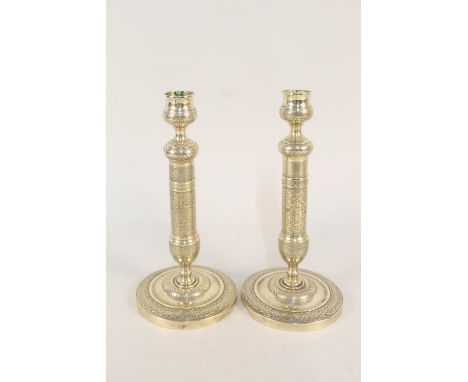A pair of early 19th Century French seamed brass candlesticks with engine decoration, 9 1/2" high