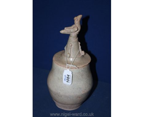A Chinese early Ming Dynasty Celadon glazed jar, the lid is modelled with a bird finial.