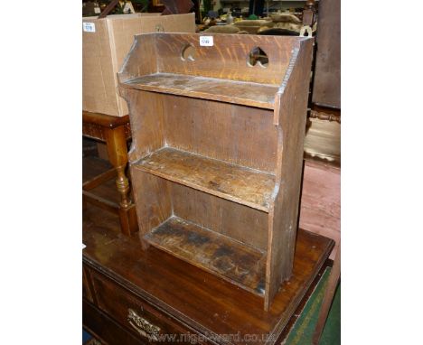 A compact Oak Wall hanging Bookshelves having inverted heart recesses to the pediment, 24'' high x 17'' wide x 6'' deep