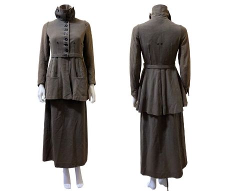 A 1910s walking suit in olive green wool with cotton lining. the jacket has a high neck with button fastening and there is ar