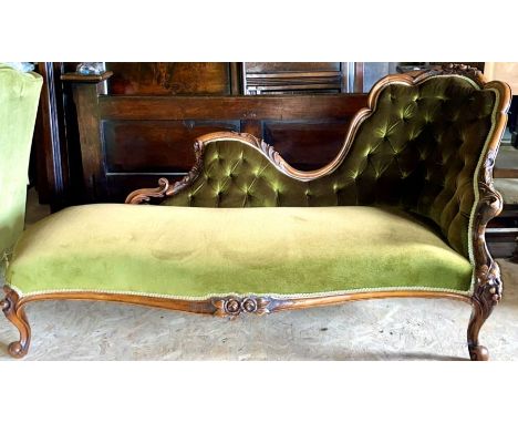 A Victorian mahogany chaise lounge, circa 1860, foliage carving throughout with a later stuffed button back rest, on a serpen