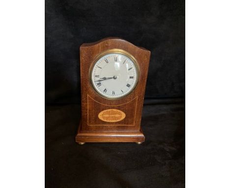 A mantle clock  with circular white dial, single train movement with balance escapement contained in a mahogany style case wi