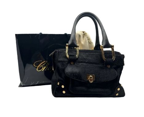 A black pony skin Chopard handbag with rose gold tone hardware, leather handles and a red jacquard lining. From the Happy Dia