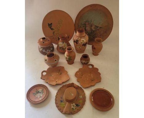 A group of Torquay terracotta wares , to include a hat wall plaque , hand painted plates and vases and other items . (1 box)