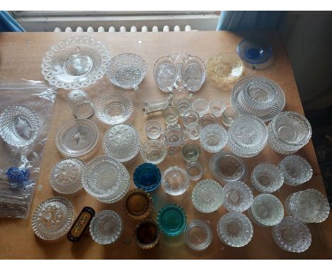 A large collection of pressed glass items, mainly candle tea light holders, varying colour ways, to include knife rests and o