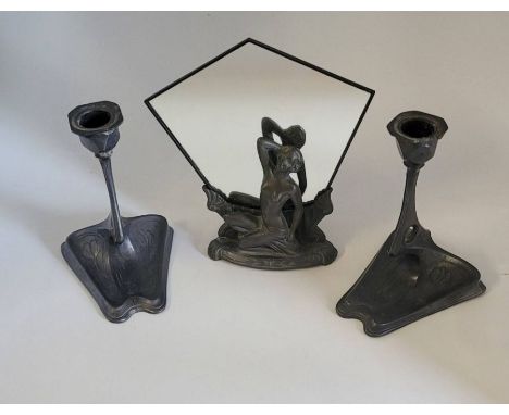 A pair of Art Nouveau pewter candlesticks with flower decoration to the bases 15cm high and an art deco mirror mounted on a p