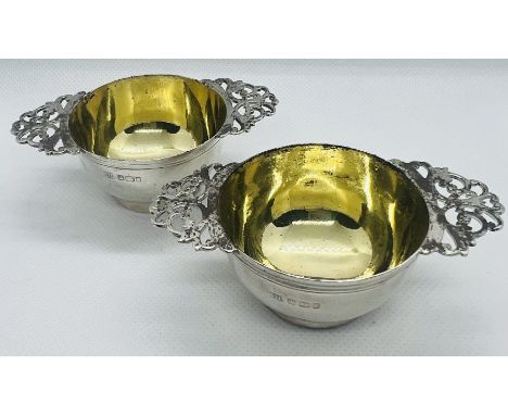 A pair of Edward VII quaich form sterling silver salts with blue glass liners. Hallmarked for Harrison Brothers &amp; Howson 