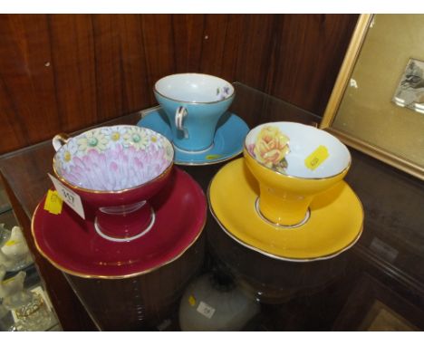 THREE FLORAL AYNSLEY CUPS AND SAUCERS