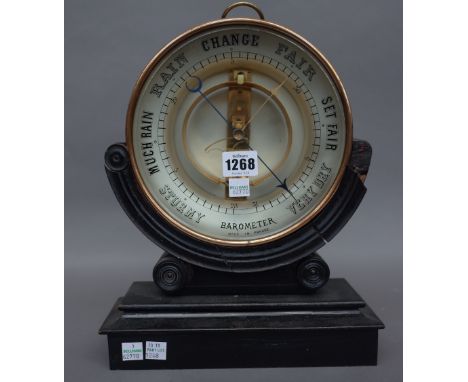 A Victorian style French brass cased barometer of circular form on a shaped wooden stand, barometer 20cm diameter.