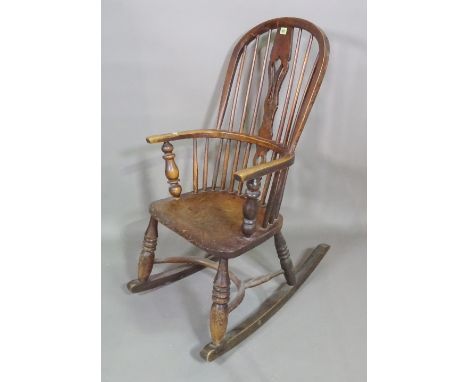 A 19th century ash and elm stick back rocking open armchair on ring turned tapering supports. 