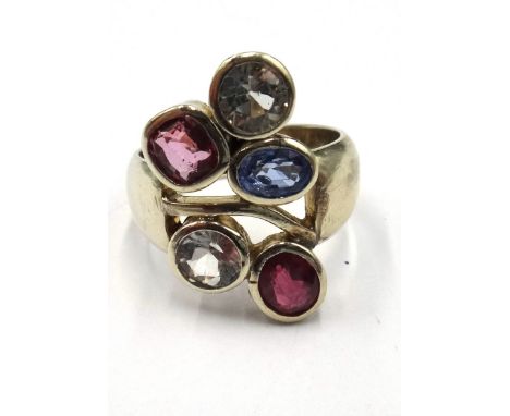 A white gold and vary coloured gemstone set five stone ring, in an abstract design, collet set with variously cut coloured ge
