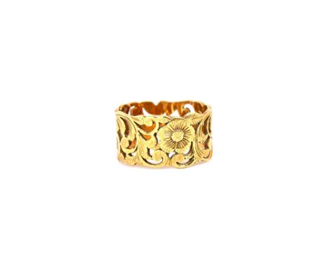 A gold wide band ring, with floral and scrolled foliate pierced and engraved decoration, detailed 750, ring size L, weight 6.