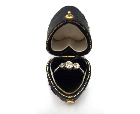 A diamond set three stone ring, claw set with cushion shaped diamonds and with the principal diamond mounted at the centre, r